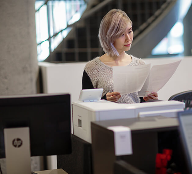 woman reading newply printed document from HP printer